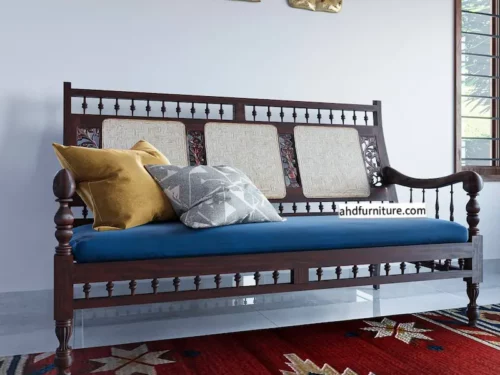 This image showcases a rosewood sofa set, a pure example of classic Indian furniture design, including a three-seater and two single-seater chairs featuring handwoven cane backrests, carved legs, grassy work on the sides, and ample sleek hand rests