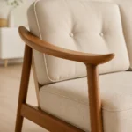 Close-up of Toby teak curved armrest, joinery and tufted beige cushion