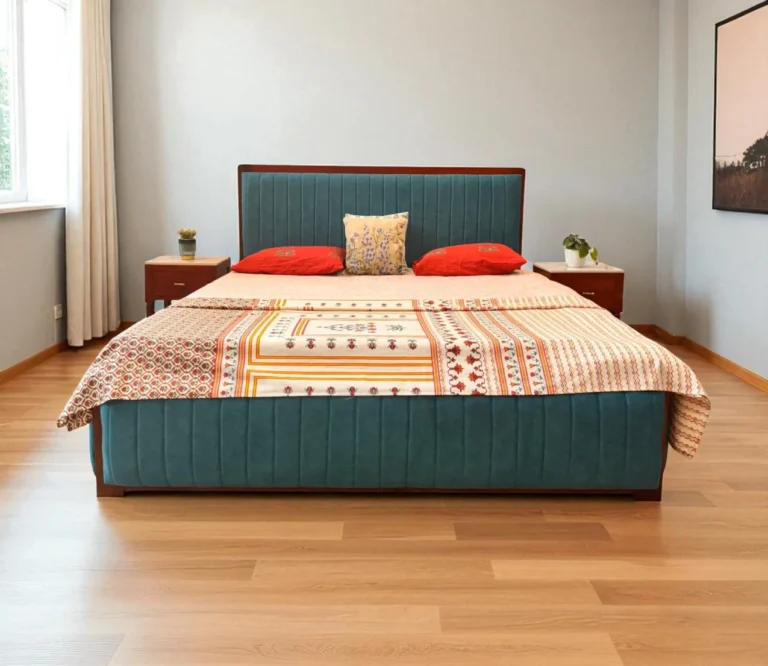 This Sarah Upholstered King Size Bed With Storage, Crafted from premium Kerala mahogany wood, this King size cot features a fully upholstered fabric design with fine vertical stitching for a sleek, modern look. The cot includes a spacious hydraulic storage system, offering easy access and ample room for organizing essentials. Its fully covered structure adds a sense of softness and sophistication, making it a perfect blend of comfort, utility, and contemporary style—ideal for today’s refined bedrooms.
