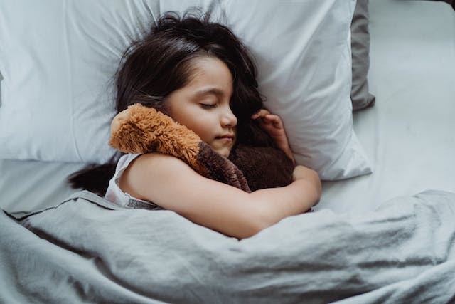 a child sleeping on a bed