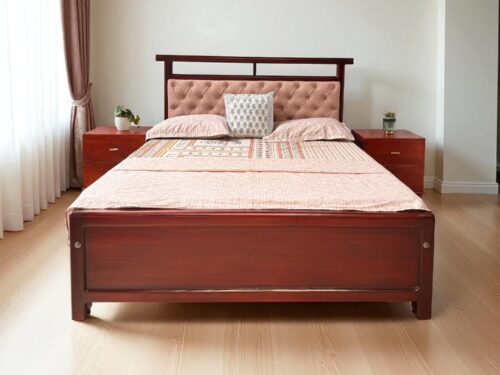 Expertly crafted from premium Kerala Mahogany wood, this Queen size cot features a classic Chesterfield-style upholstered headboard with deep tufting for a luxurious touch. The design is fully side-covered for a seamless look, and the top of the headboard is accented with a graceful wooden rod detail. Its minimalist silhouette complements both traditional and modern interiors, while the fabric color can be customized to suit your personal style. A timeless piece that blends comfort, craftsmanship, and understated elegance.