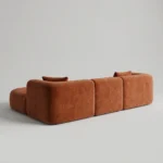 Rear view of rust velvet curved L-shaped sofa